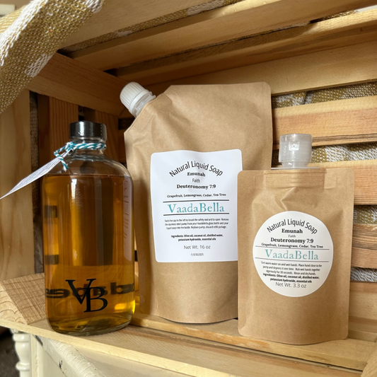 16 oz glass bottle with black lid, 16 oz brown pouch with pour spout, 3.3 oz brown pouch with flip top; all inside a wooden crate