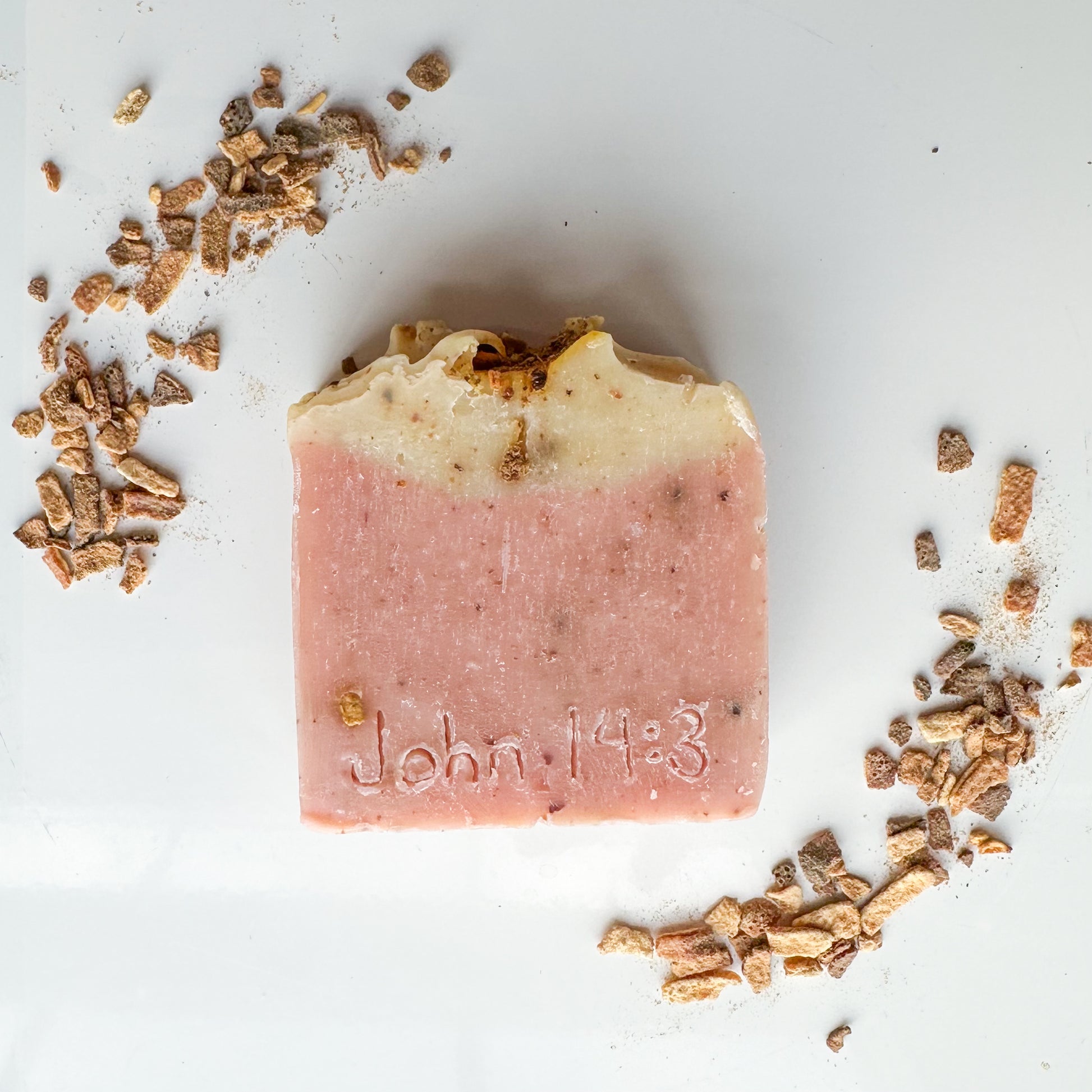 Bar with pink bottom, light yellow top, citrus zest sprinkled throughout.  John 14:3 etched into the front.  Citrus zest sprinkled in the top left and bottom right of the image.  White background