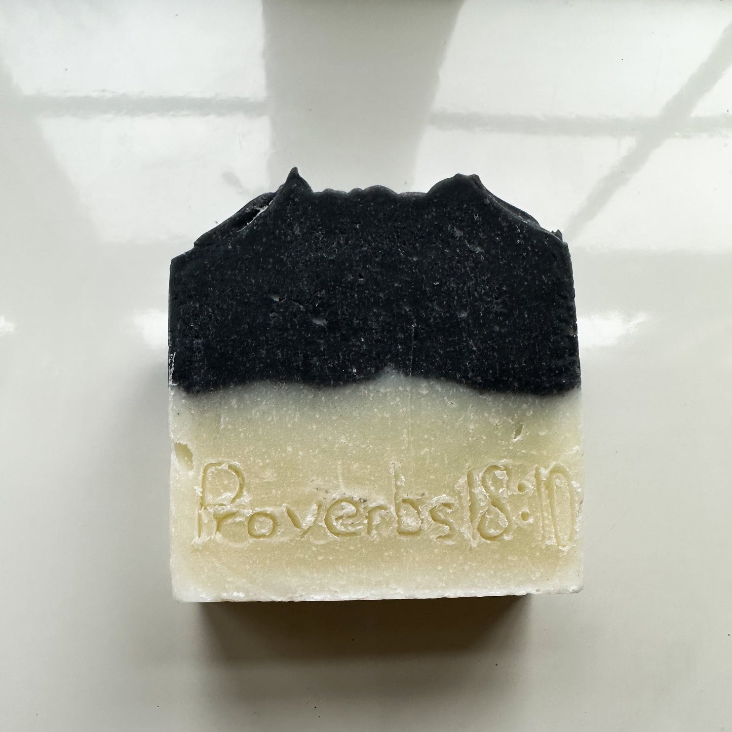 White bottom, black top bar, no product sleeve.  "Proverbs 18:10" is etched into the bar.
